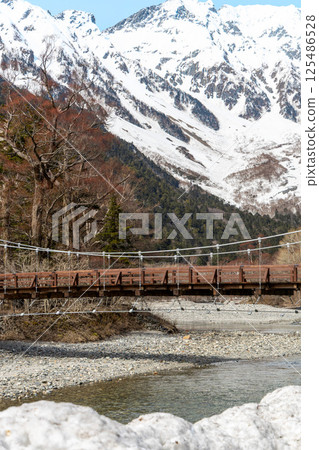 Quiet Kamikochi in spring before the mountain opens. Kappa Bridge, the Hotaka mountain range, and the Azusa River. Quiet Kamikochi in spring before the mountain opens. Kappa Bridge, the Hotaka mountain range, and the Azusa River. 125486528