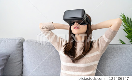 AI image: A woman enjoying virtual reality in her living room using a head-mounted display 125486547