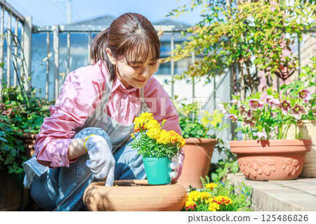 Woman planting flowers Gardening 125486826
