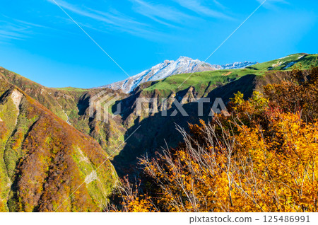 Mount Chokai, Yamagata - White snow-capped summit and autumn foliage at the base - Mount Chokai, Yamagata - White snow-capped summit and autumn foliage at the base - 125486991