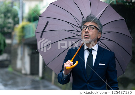 一個男人用一把雨傘 一個男人用一把雨傘 125487180