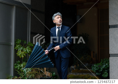 一個男人用一把雨傘 一個男人用一把雨傘 125487217