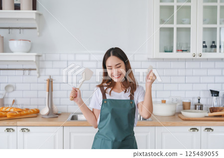 Young Asian woman dancing in the kitchen 125489055