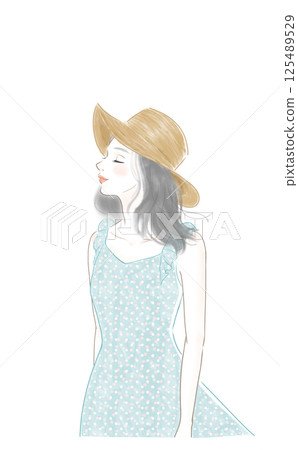 一位身穿夏裝、戴著草帽的女子感受著風 125489529