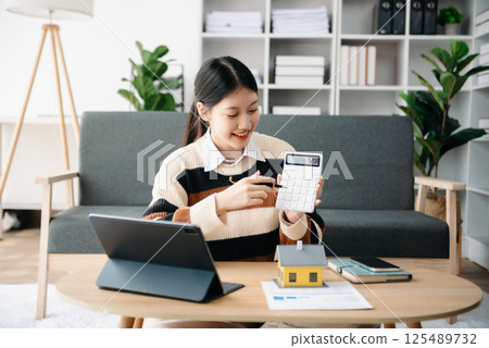 Asian woman working with House model real estate agent and customer discussing for contract to buy house, insurance or loan real estate consult concerning mortgage loan offer 125489732
