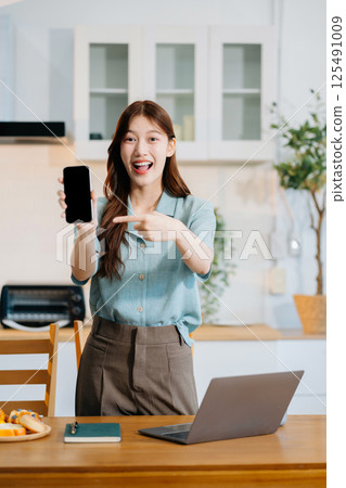 lifestyle Happy woman speaking to mobile phone at home. women speak with remote friend using phone. 125491009