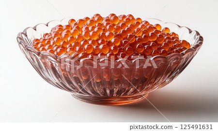 Details showcase vibrant salmon roe presented in an elegant glass bowl with intricate design against a clean, minimalistic backdrop 125491631