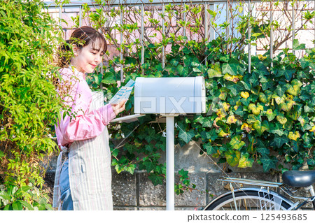 Woman taking out mail 125493685