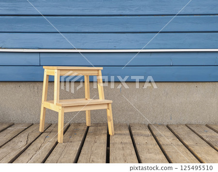 Ladder stool against a wooden home wall. Ladder stool against a wooden home wall. 125495510