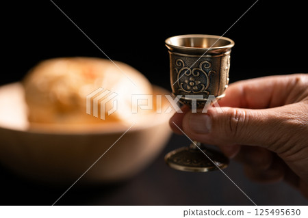 Sacred ceremony of Communion, Christians express their faith by partaking in holy bread, deepening their spiritual connection with God within the church. communion, religion, christian, faith, holy. 125495630