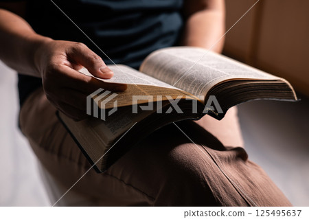 Woman of faith holds the Bible in her hand, believing deeply in the teachings of Jesus Christ and the presence of God, embodying her Christian religion. bible, person, hand, religion, book, faith. Woman of faith holds the Bible in her hand, believing deeply in the teachings of Jesus Christ and the presence of God, embodying her Christian religion. bible, person, hand, religion, book, faith. 125495637
