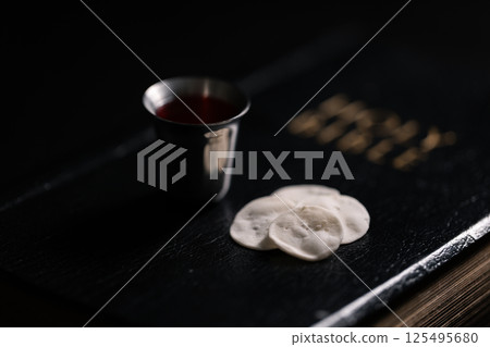 Communion, Christians celebrate their faith by partaking in bread and wine, symbolizing the body and blood of Jesus Christ, as taught in the Bible and cherished in their holy religion. communion, holy 125495680
