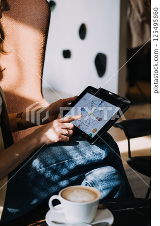 Numerologist using a tablet to interpret a digital numerology chart in a sunlit room. Modern numerology, metaphysical tech, intuitive design, spiritual analytics... Numerologist using a tablet to interpret a digital numerology chart in a sunlit room. Modern numerology, metaphysical tech, intuitive design, spiritual analytics... 125495860