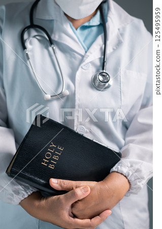 Doctor clasped their hands in prayer, hoping for the best as they provided medical care in hospital clinic. doctor, pray, medicine, health, medical, hand, hospital, care, clinic, hope, prayer, person. 125495959