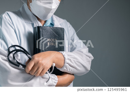 Doctor clasped their hands in prayer, hoping for the best as they provided medical care in hospital clinic. doctor, pray, medicine, health, medical, hand, hospital, care, clinic, hope, prayer, person. 125495961