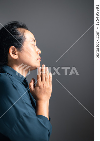 Woman raises her hand in prayer, with deep faith in God, worshiping Jesus Christ in a moment of holy peace and devotion. woman, hand, pray, faith, religion, jesus christ, christian, god, holy. Woman raises her hand in prayer, with deep faith in God, worshiping Jesus Christ in a moment of holy peace and devotion. woman, hand, pray, faith, religion, jesus christ, christian, god, holy. 125495991