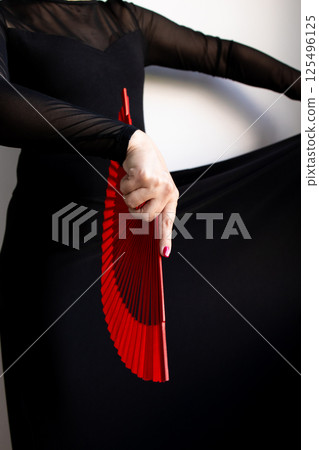 Female dancer in black dress with red fan. Expression of flamenco art Female dancer in black dress with red fan. Expression of flamenco art 125496125