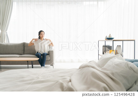 一個女人坐在沙發上和放鬆 一個女人坐在沙發上和放鬆 125496428