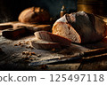 Artisan bread in a dark, moody bakery scene, highlighted by dramatic lighting. 125497118