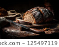 Artisan bread in a dark, moody bakery scene, highlighted by dramatic lighting. 125497119