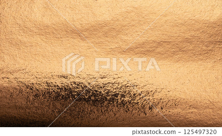 Copper foil background with a rough, metallic texture. Golden, polished surface with a glowing, 125497320