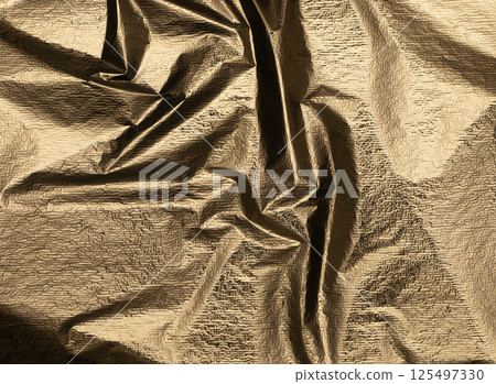 Crumpled brass and gold foil texture with a pearlescent, shiny finish. Rough folds and crinkles Crumpled brass and gold foil texture with a pearlescent, shiny finish. Rough folds and crinkles 125497330