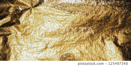 Gold foil background with grainy texture and metallic sheen. Crumpled surface with shiny, reflective Gold foil background with grainy texture and metallic sheen. Crumpled surface with shiny, reflective 125497348