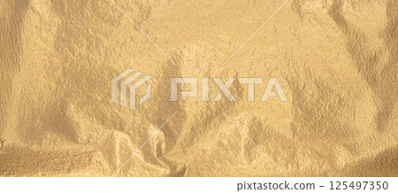 Gold foil background with wrinkled texture and soft matte finish. Reflective metallic sheet with Gold foil background with wrinkled texture and soft matte finish. Reflective metallic sheet with 125497350