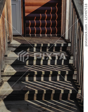 abstract unique patterns shadows created by wooden stair in rustic setting during daytime. abstract unique patterns shadows created by wooden stair in rustic setting during daytime. 125497518