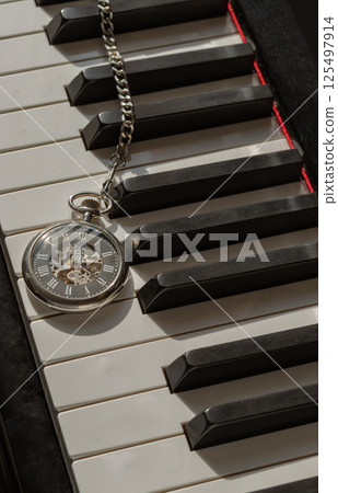 Antique pocket watch or Retro pocket watch on Piano keys background. 125497914