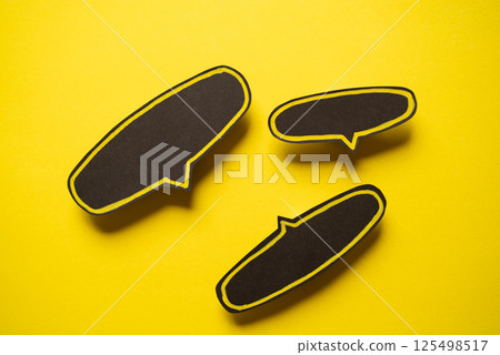 Black speech bubble on a yellow background Black speech bubble on a yellow background 125498517