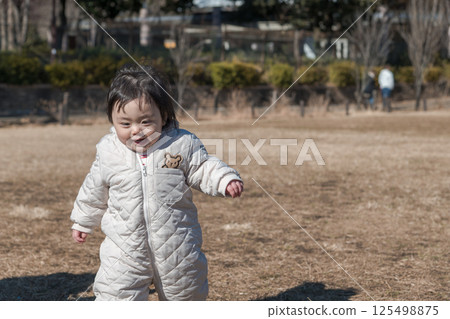 [一歲兒童在相模原市立麻溝公園的草地上玩耍] 125498875