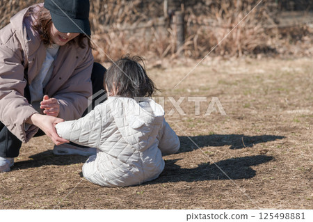 [一名一歲兒童和他的母親在相模原市麻溝公園的草地上玩耍] 125498881