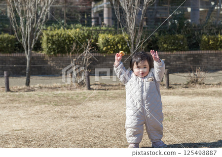 [一歲兒童在相模原市立麻溝公園的草地上玩耍] 125498887