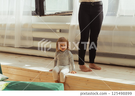 Little child playing indoors while parent works remotely. Family life and work from home concept. 125498899