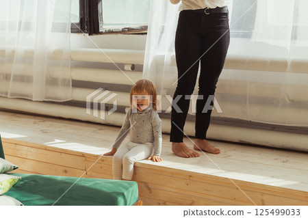 Little child playing indoors while parent works remotely. Family life and work from home concept. 125499033