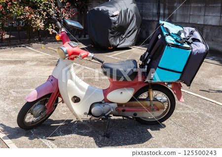 Small motorbikes delivering food online 125500243