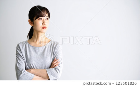 AI 圖片：一位年輕女子雙手交叉思考 125501826