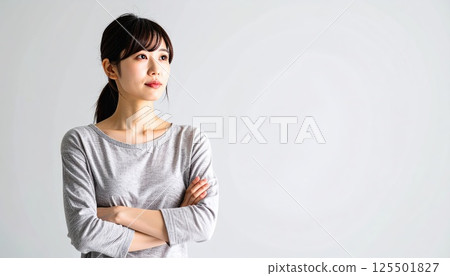 AI 圖片：一位年輕女子雙手交叉思考 125501827