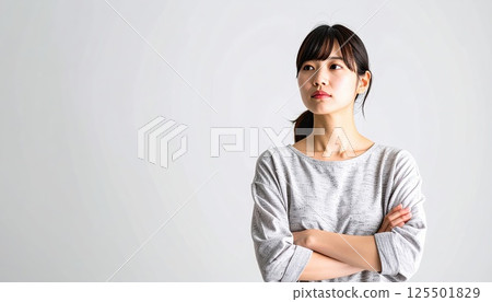 AI 圖片：一位年輕女子雙手交叉思考 125501829