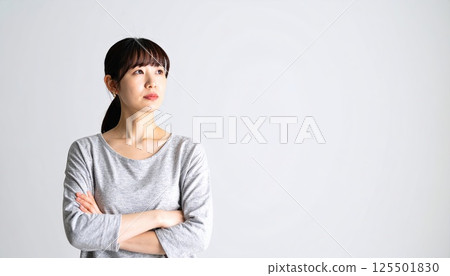AI image: A young woman thinking with her arms folded AI image: A young woman thinking with her arms folded 125501830