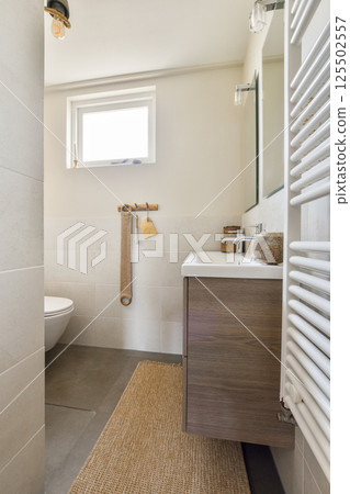 The image showcases a contemporary bathroom featuring sleek designs, natural light, and warm accents, emphasizing both functionality and aesthetics. The image showcases a contemporary bathroom featuring sleek designs, natural light, and warm accents, emphasizing both functionality and aesthetics. 125502557
