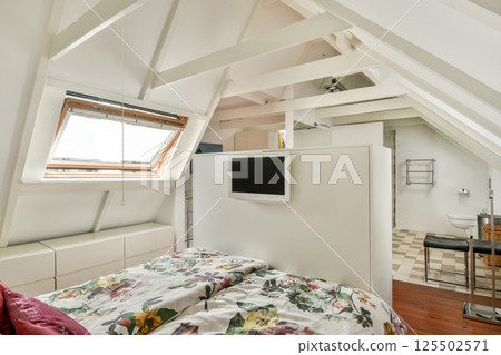 A stylish and modern bedroom featuring a comfortable bed with floral bedding and minimalistic decor that promotes relaxation and tranquility. 125502571