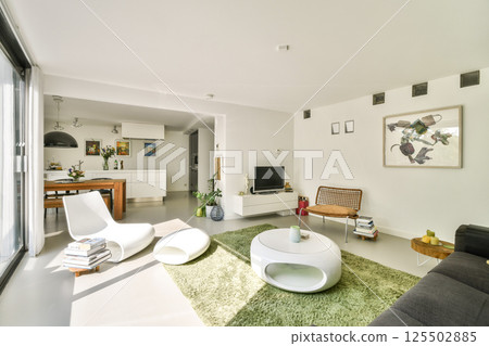 A sleek, contemporary living room featuring minimalist furniture, a cozy atmosphere, and vibrant touches from decor elements. The space feels airy and inviting. A sleek, contemporary living room featuring minimalist furniture, a cozy atmosphere, and vibrant touches from decor elements. The space feels airy and inviting. 125502885