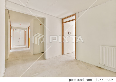 A spacious, minimalistic interior hallway showcasing empty walls and doors. The bright, clean design emphasizes simplicity and open space. 125502906