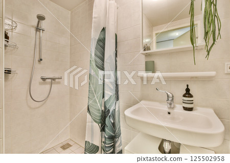 A stylish bathroom featuring a tropical-themed shower curtain and sleek fixtures, showcasing a blend of functionality and contemporary design. 125502958