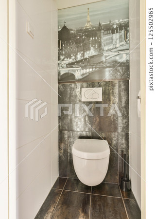 This contemporary bathroom features an elegant toilet design and a stunning black-and-white mural of Paris, enhancing the aesthetic ambiance. 125502965