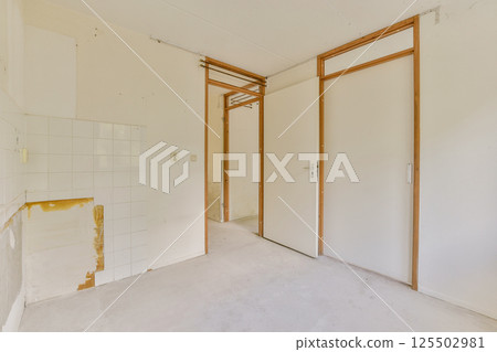 An empty room showcasing modern minimalist architecture with white walls and wooden accents. Perfect for interior design inspiration or renovation ideas. An empty room showcasing modern minimalist architecture with white walls and wooden accents. Perfect for interior design inspiration or renovation ideas. 125502981