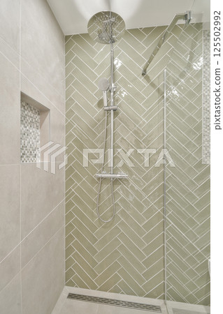 Sleek and contemporary shower featured in a modern bathroom, showcasing elegant tile work and high-quality fixtures. Ideal for design inspiration. Sleek and contemporary shower featured in a modern bathroom, showcasing elegant tile work and high-quality fixtures. Ideal for design inspiration. 125502992