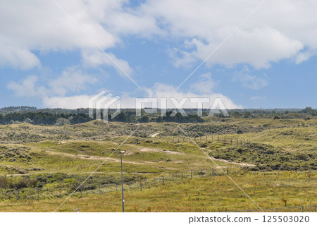 A wide view of a verdant landscape under a partly cloudy sky, featuring rolling hills and a serene atmosphere, ideal for nature enthusiasts and photographers. A wide view of a verdant landscape under a partly cloudy sky, featuring rolling hills and a serene atmosphere, ideal for nature enthusiasts and photographers. 125503020